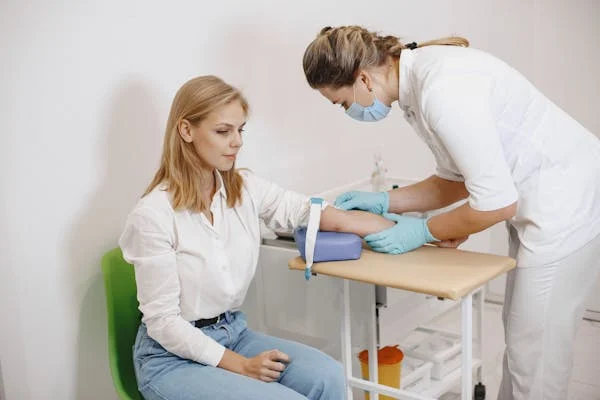 Médica realizando una extracción de sangre